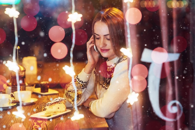 Young beautiful woman sitting in cafe, drinking wine. Christmas, new year, Valentines day, winter holidays 