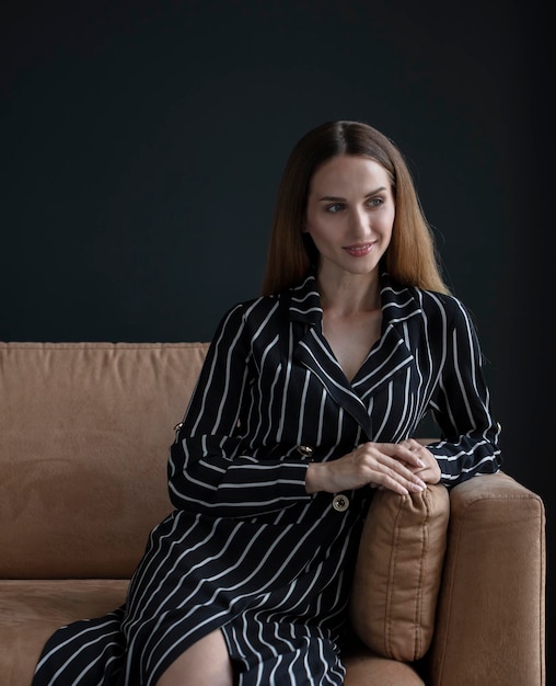 young beautiful woman sitting on a sofa near the window