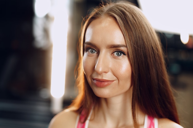 Young beautiful woman in sportswear in a gym close up