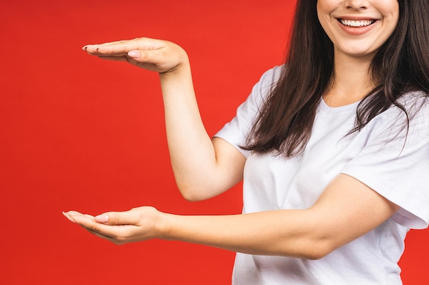 Giovane bella donna in piedi isolato su sfondo rosso sorridente mostrando entrambe le mani palmi aperti presentando e pubblicità confronto ed equilibrio