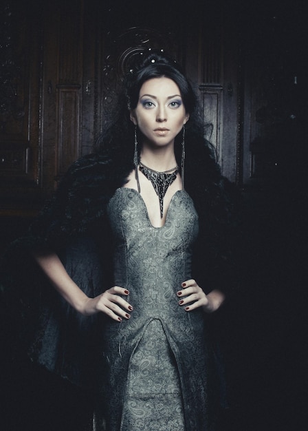 Young beautiful woman standing in the palace room