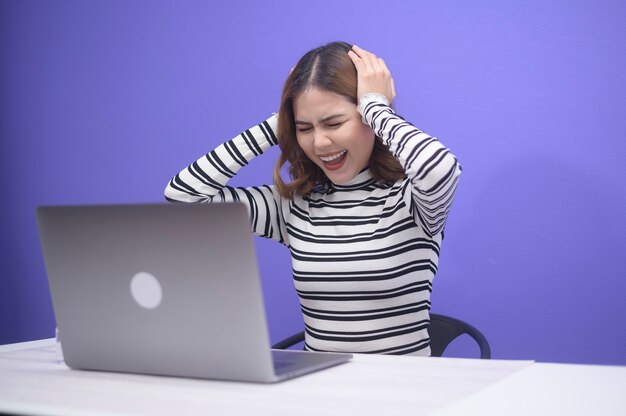 Una giovane bella donna stressata dal lavoro sul blu, concetto di salute mentale