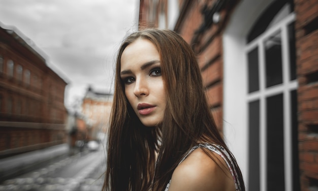 Young beautiful woman in summer dress on street on city