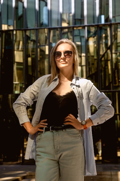 young beautiful woman in sunglasses posing in the courtyard of the business center