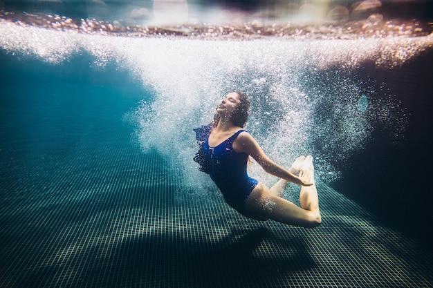 Молодая красивая женщина плавает под водойxA