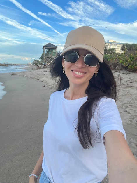 Young beautiful woman taking selfie on the beach