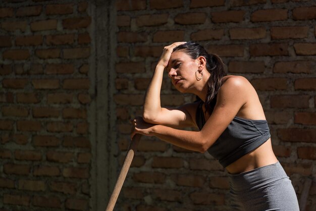 Young and beautiful woman tired of working on the land with heat under the sun