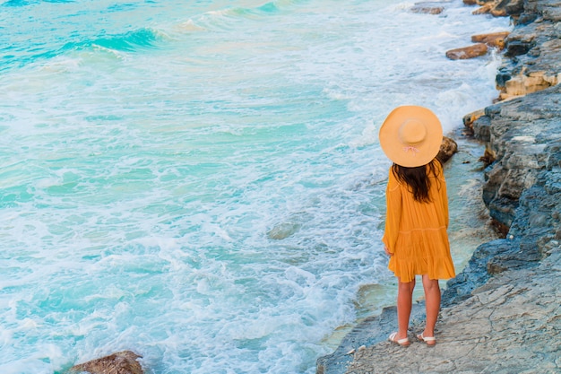 Young beautiful woman on tropical seashore in sunset.