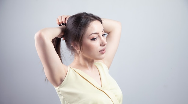 Young beautiful woman tying her hair.