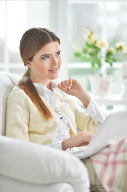 Young beautiful woman using laptop at home