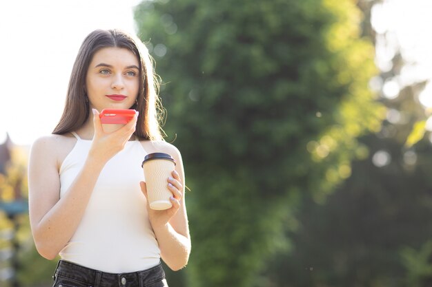 Young beautiful woman using the phone in the park