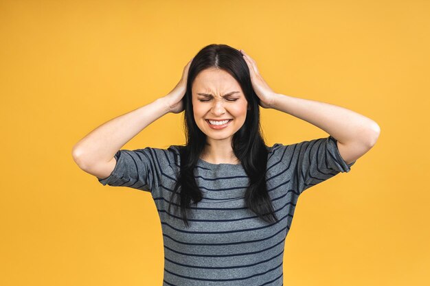 Young beautiful woman wearing casual isolated over yellow
background suffering from headache desperately and stressed because
pain and migraine hands on head