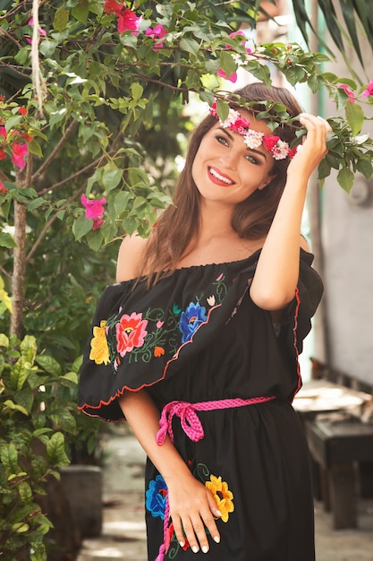 Photo young beautiful woman wearing traditional mexican dress on the city street