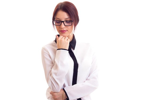 Young beautiful woman in white-and-black shirt with black glasses on white background in studio