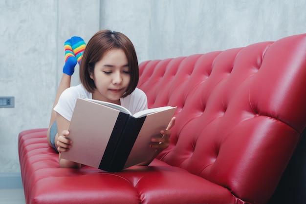 Young beautiful woman in white lingerie reading book in the bedrest