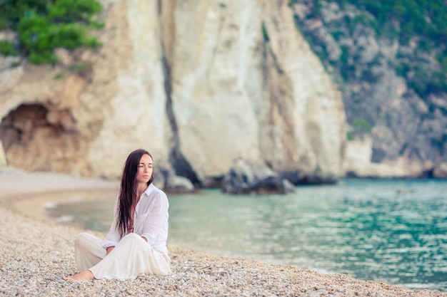 하얀 모래 열 대 해변에서 젊은 아름 다운 여자. 바다에 모자에 백인 여자