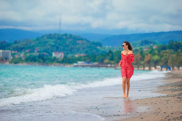 Young beautiful woman on white sand tropical beach