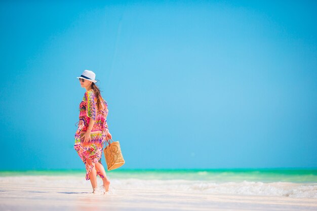 Young beautiful woman on white sand tropical beach