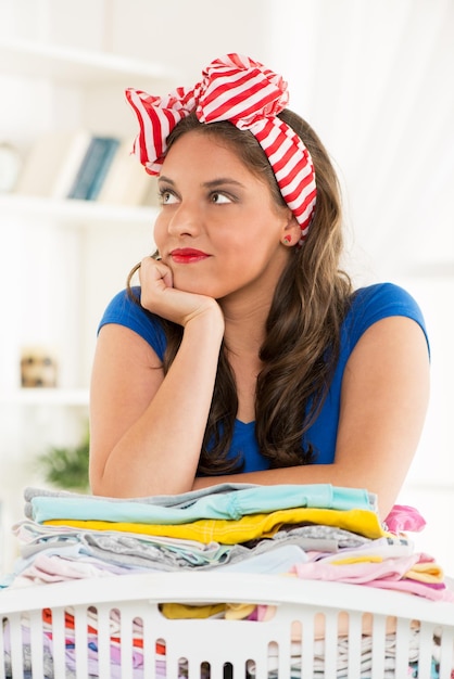 Photo young beautiful woman with basket laundry for ironing