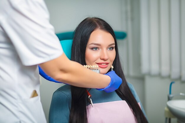 Young beautiful woman with beautiful white teeth sitting on a dental chair.