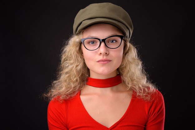 Young beautiful woman with blond curly hair against gray