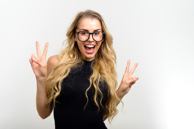 young beautiful woman with blonde wavy hair against white wall