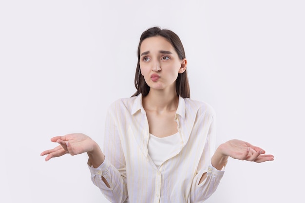 Young beautiful woman with facial expression of surprise standing over white background