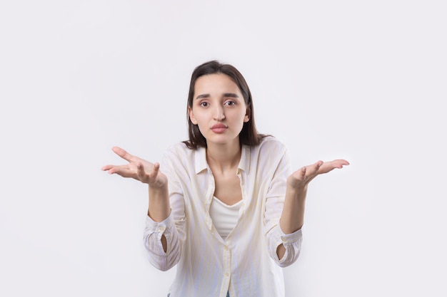 Young beautiful woman with facial expression of surprise standing over white background