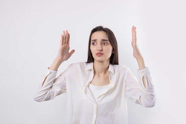 Young beautiful woman with facial expression of surprise standing over white background