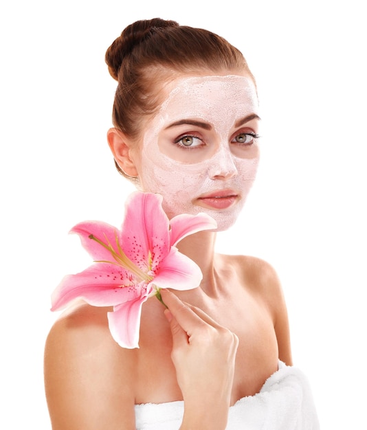 Young beautiful woman with facial mask and lily flower isolated on white