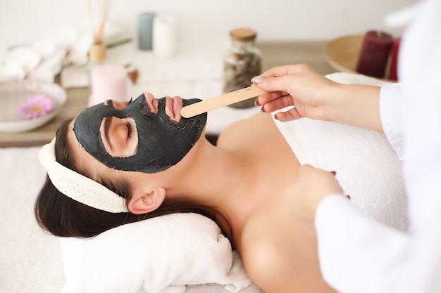 Young beautiful woman with facial mask, spa treatment