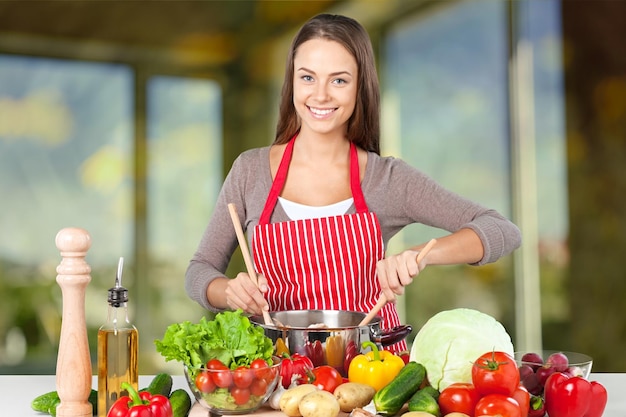 Young beautiful woman with fresh vegetables cooking