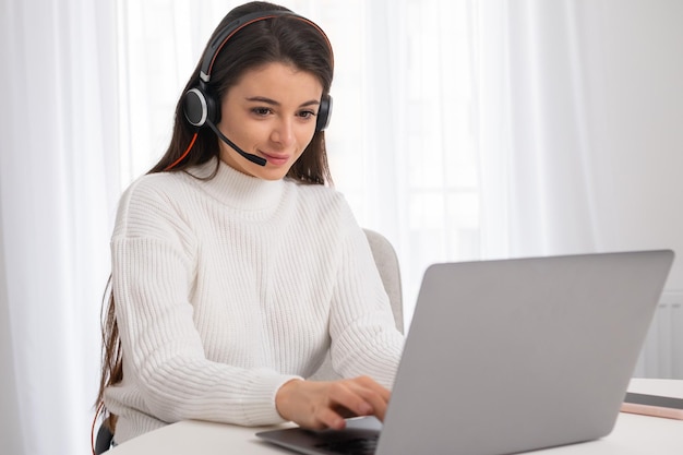 A young beautiful woman with headphones is engaged in online education