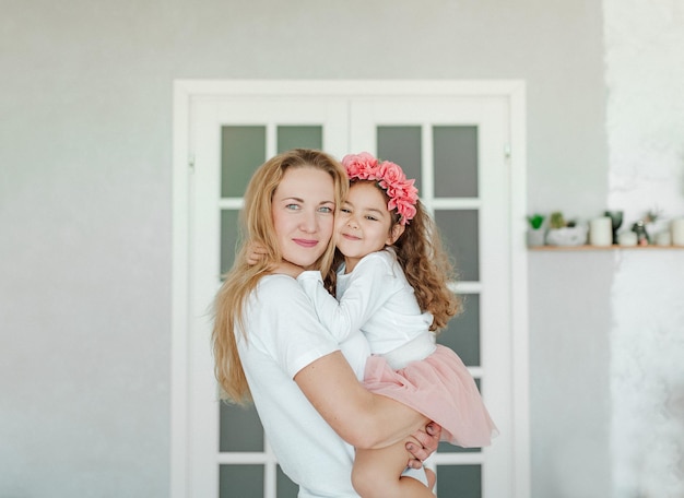 Young beautiful woman with her daughter. Studio shot. Mother and daughter enjoy time together. Motherhood and mothers day concept