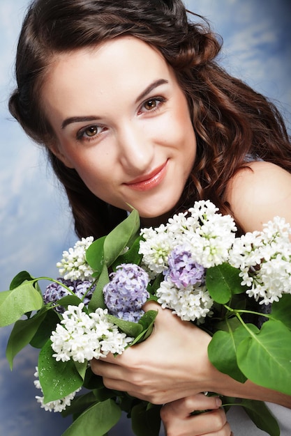 Young beautiful woman with lilac flowers