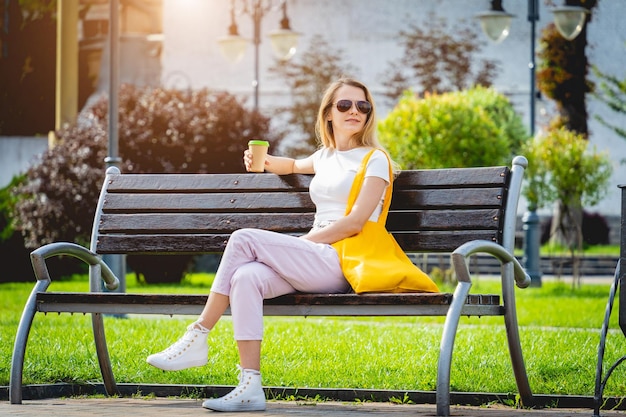 Young beautiful woman with linen eco bag on city background