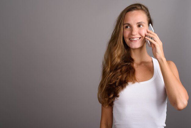 Young beautiful woman with long blond hair using mobile phone