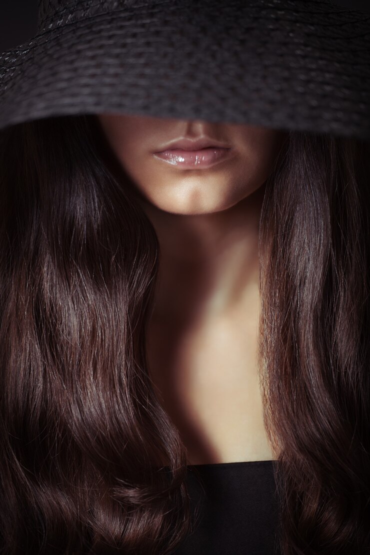Young beautiful woman with long hair in dark, studio shot