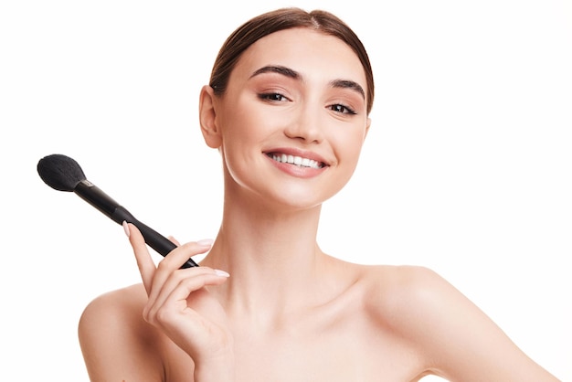 Young beautiful woman with makeup brush for powder