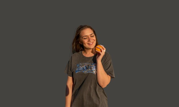 Photo young beautiful woman with orange smiling and happy