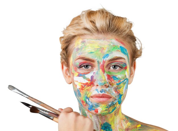 Young beautiful woman with painted  face and paintbrushes