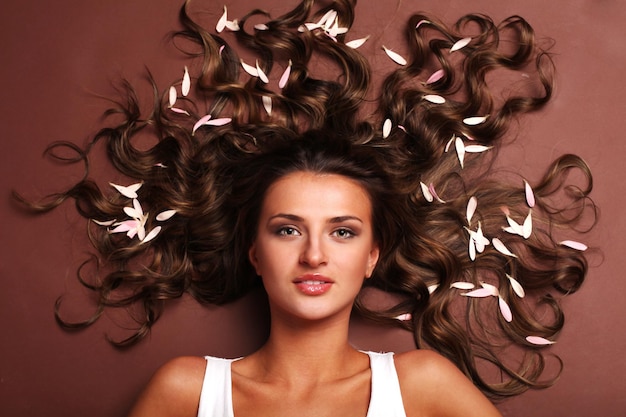 Young beautiful woman with petals in her hair