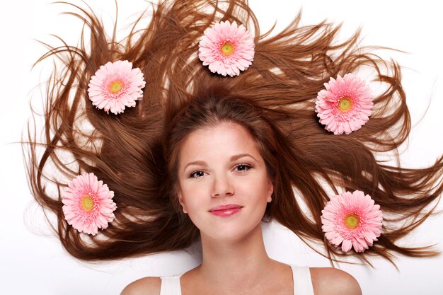 Young beautiful woman with pink fresh flower