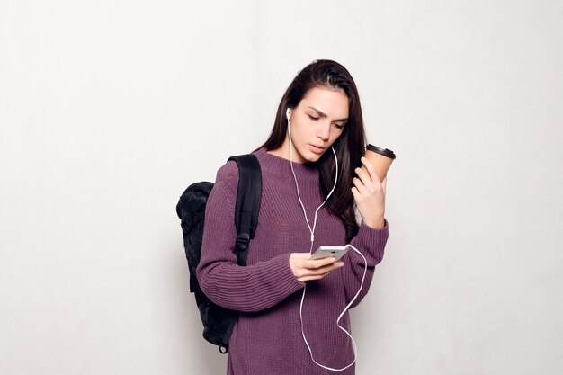 Young beautiful woman with smart phone and backpack