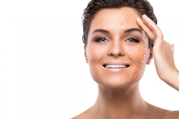 Young beautiful woman with sugar scrub on her face