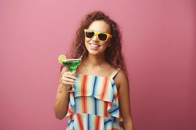 Young beautiful woman with tasty cocktail on color background