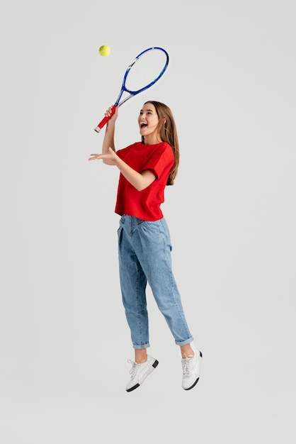 Photo young beautiful woman with tennis racket jumping