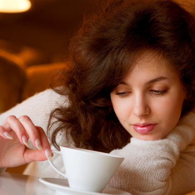 Young beautiful woman with a white cup