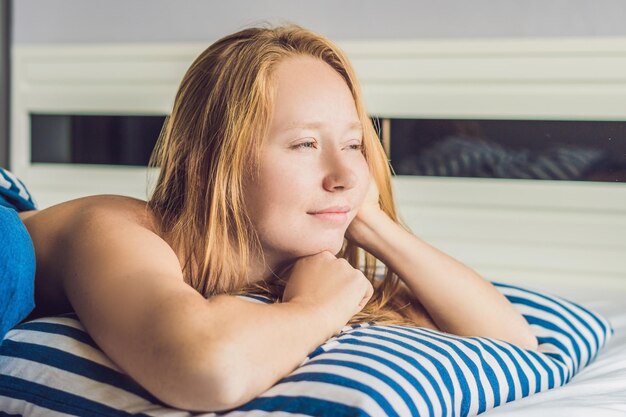 Young beautiful woman woke up in bed close-up