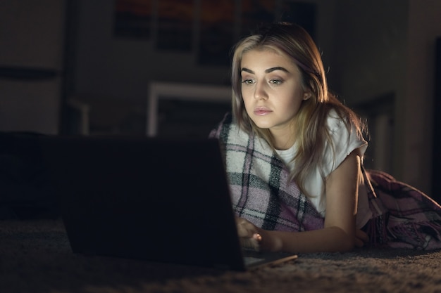 young beautiful woman working at home remotely at night